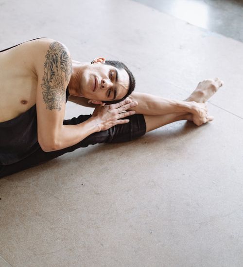 Focused man in a stretching pose, showing flexibility and balance.